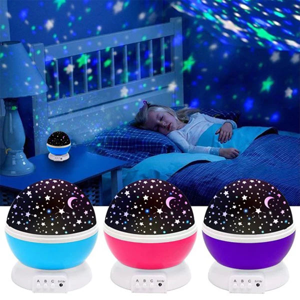 Starry night light projector on a bed with a child sleeping, surrounded by three different colored night lights.