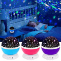 Starry night light projector on a bed with a child sleeping, surrounded by three different colored night lights.